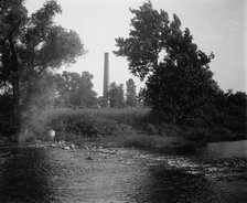 Smokestack by river, probably the Huron River, Ypsilanti, Michigan, between 1900 and 1910. Creator: Unknown.