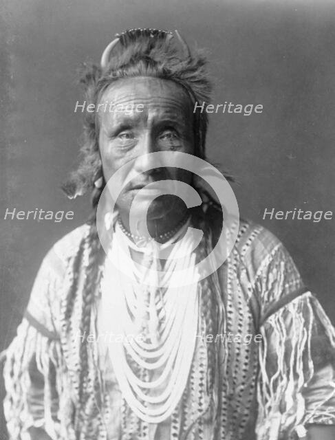 The Grizzly Bear, Piegan, half-length portrait, facing front, c1910. Creator: Edward Sheriff Curtis.