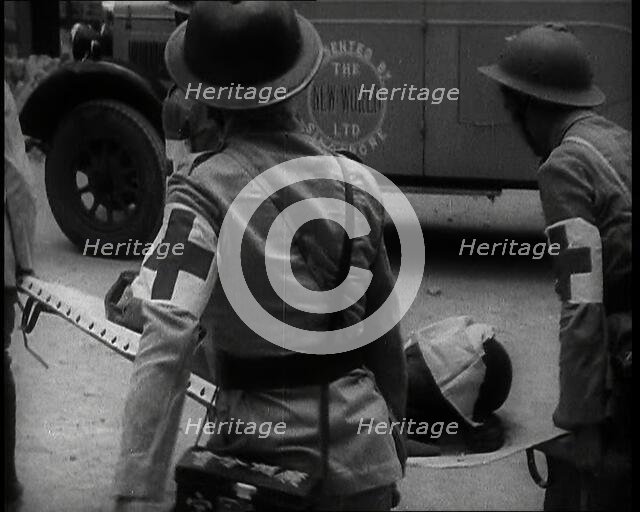 Four Chinese Red Cross Society of China Staff Carrying a Stretcher Supporting an Injured..., 1938. Creator: British Pathe Ltd.