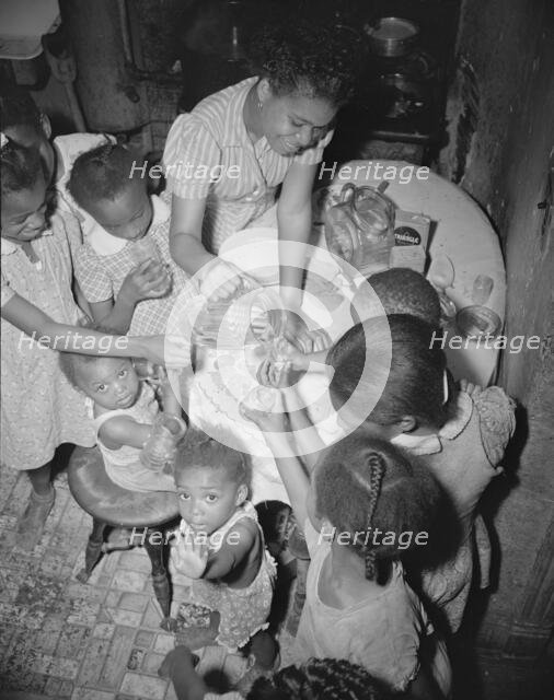 Pouring lemonade at a birthday party on Seaton Road, Washington, D.C., 1942. Creator: Gordon Parks.