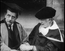 Sir James Barrie and Ellen Terry Sitting Together in Academic Dress Outside St Andrew's Uni, 1922. Creator: British Pathe Ltd.
