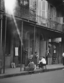 View from across street of two women talking, New Orleans, between 1920 and 1926. Creator: Arnold Genthe.