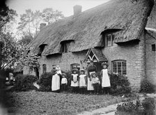 Women and children outside a thatched cottage, Marsh Gibbon, Buckinghamshire, 1904. Artist: Alfred Newton & Sons.