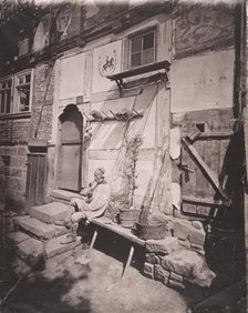 [Man Smoking Pipe Outside His Home on Village Street], 1880s. Creator: Unknown.