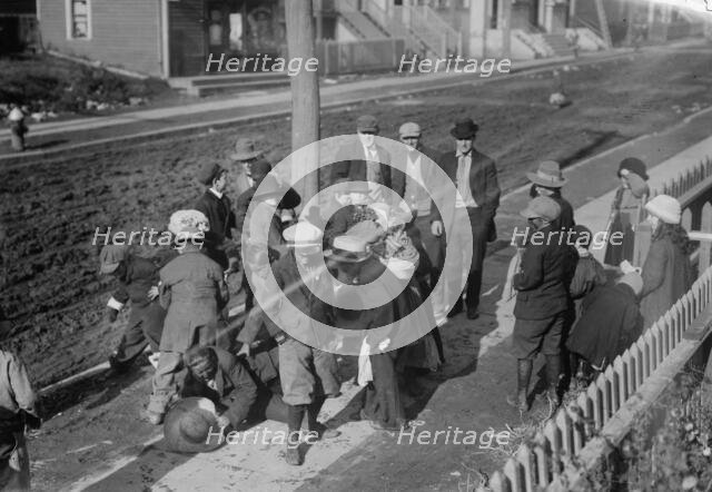 Thanksgiving Maskers scramble for pennies, between c1910 and c1915. Creator: Bain News Service.