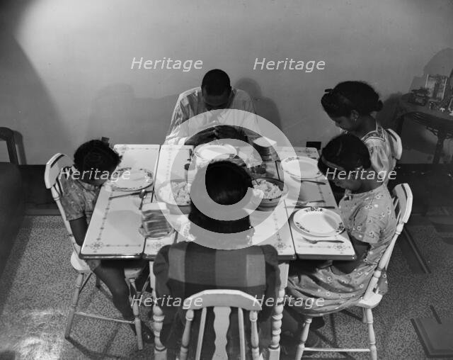 Mr. Branch, resident of the James Creek dwellings, saying grace, Washington, D.C., 1942. Creator: Gordon Parks.