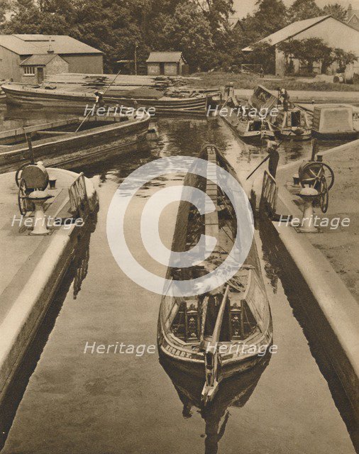 'Pushing a Monkey Boat Through The Lock at Brentford', c1935. Creator: Unknown.