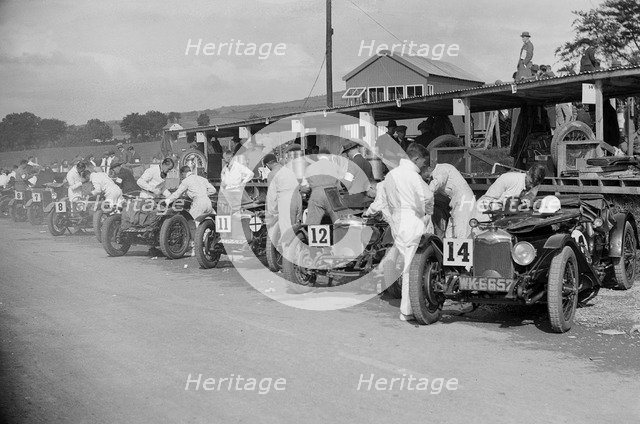Triumph and Riley cars in the pits at the RAC TT Race, Ards Circuit, Belfast, 1929 Artist: Bill Brunell.