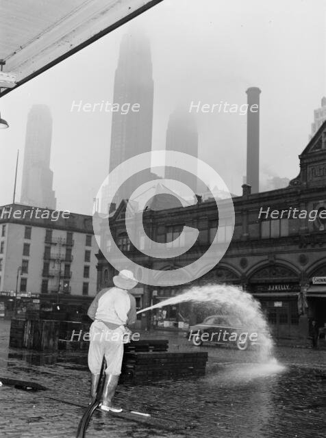 City sanitation workman washing streets at Fulton fish market, New York, 1943. Creator: Gordon Parks.