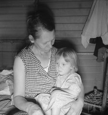Mother from Oklahoma, awaits visit of resident nurse for sick baby, FSA camp, Farmersville, CA, 1939 Creator: Dorothea Lange.