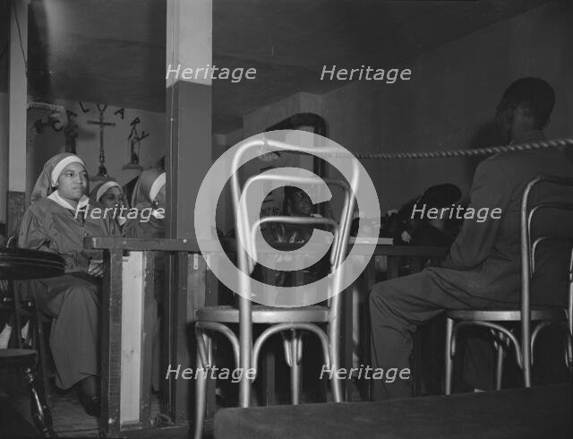 "Saints" in the congregation of the St. Martin's Spiritual Church, Washington, D.C., 1942. Creator: Gordon Parks.