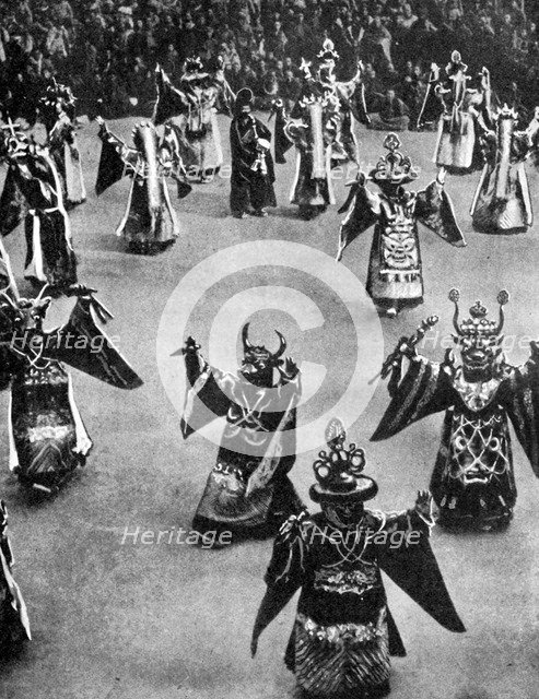Masked dancers, Tibet, 1936.Artist: Ewing Galloway