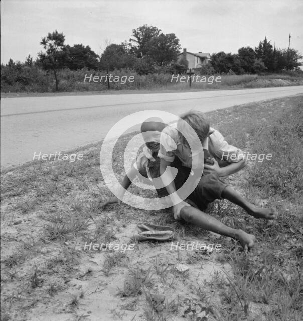 White and Negro boy wrestling by side of road, Person County, North Carolina, 1939. Creator: Dorothea Lange.