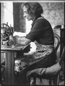 A glover or glove maker working at a sewing machine, Woodstock, Oxfordshire, 1920-1940.  Creator: George R Long.