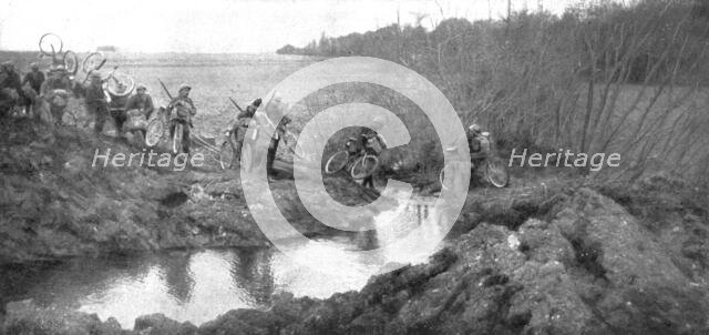 'L'avance Francaise; La traversee d'un ruisseau par un groupe cycliste: il existait la un petit pont Creator: Unknown.