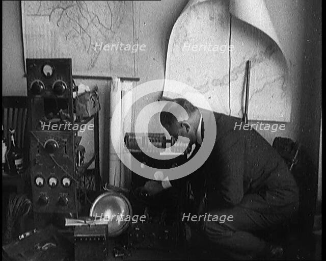Male Detective Showing off Smugglers' Radio Equipment, 1929. Creator: British Pathe Ltd.