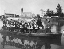 Marshall Erwin in front of a boat containing a kill of ducks, between c1900 and 1927. Creator: Unknown.