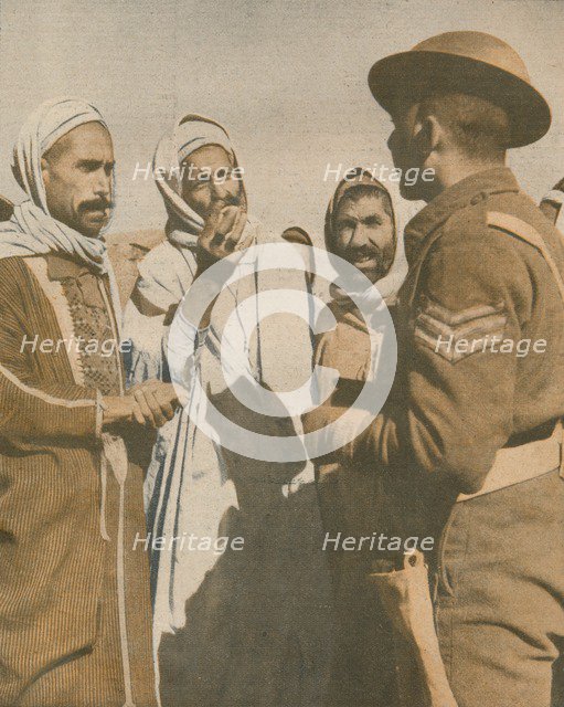 'Tunisian Arabs Welcome a British Sergeant at Chaouach', 1943. Artist: Unknown.