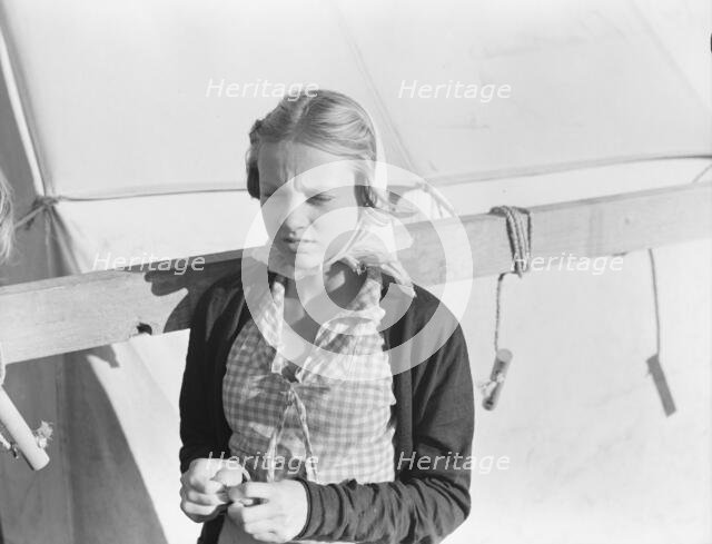 Young girl, migratory worker, beside the tent in which she lives, Kern County, California, 1938. Creator: Dorothea Lange.