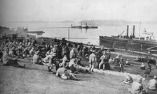 ''Austrian prisoners taken by Serbians resting at mid-day on the banks of the Danube', 1915.  Artist: Unknown.