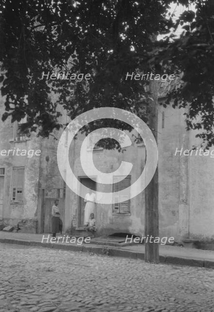 Woman and children standing in or by a doorway, [17 Chalmers Street], Charleston..., c1920-c1926. Creator: Arnold Genthe.