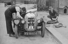 Working on the engine of E Martin's Austin Swallow at the North West London Motor Club Trial, 1929. Artist: Bill Brunell.