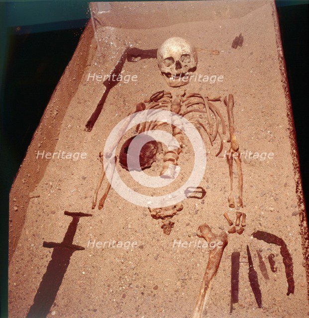 Viking Burial of Man with Axe, Spear, Sword , Knives, Shield and Belt Buckle, 9th-10th century. Artist: Unknown.