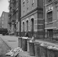 Street scene showing open trash cans along the curb, New York, 1943. Creator: Gordon Parks.