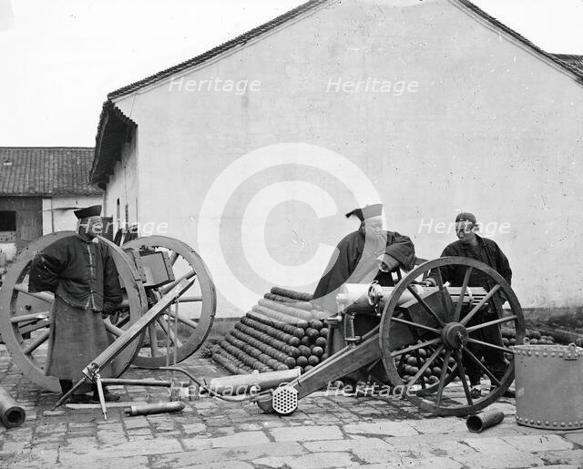 Nanking, Kiangsu province, China: three men examining a gun at the arsenal, 1871. Creator: John Thomson.