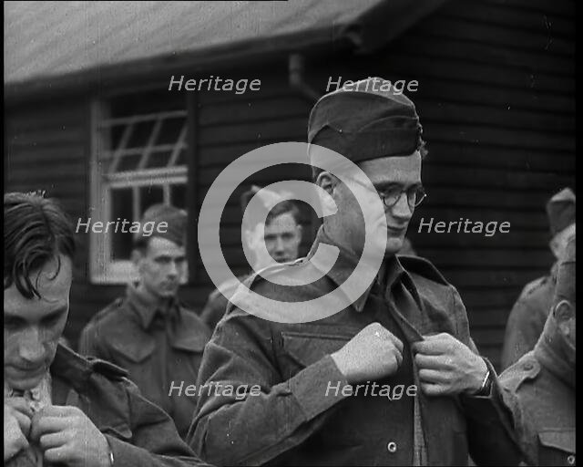 Close up on a Male British Soldier Wearing a Side Cap and Round-Rimmed Glasses Buttoning up..., 1939 Creator: British Pathe Ltd.