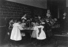 Children in school in Washington, D.C. - learning how a compass is made, (1899?). Creator: Frances Benjamin Johnston.