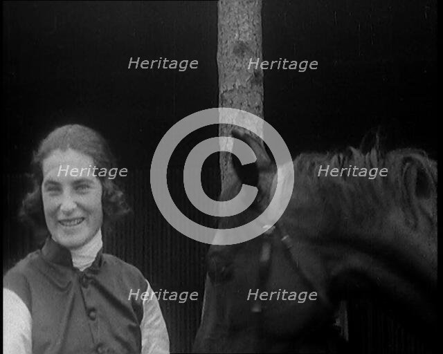 A Female Civilian Wearing a Jockey's Outfit Removing Her Hat in Front of Her Horse and..., 1920. Creator: British Pathe Ltd.
