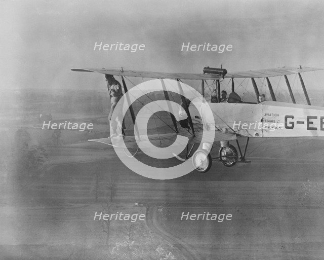 Wing walking without a harness on an Avro 504 biplane, 1932. Creator: Aerofilms.