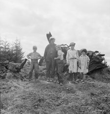 Mrs. Arnold and her children before the stump pile, Michigan Hill, Thurston County, Washington, 1939 Creator: Dorothea Lange.