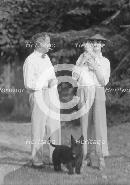 Leonard, Mr. and Mrs., with cat and dog, standing outdoors, between 1926 and 1938. Creator: Arnold Genthe.