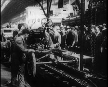 A Group of Male Civilians Building a Car As a Crowd of People Watch. Behind the Crowd..., 1924. Creator: British Pathe Ltd.