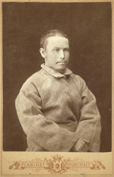 Half-length portrait of a man in convict coat, seated, facing right, between 1880 and 1886. Creator: Unknown.