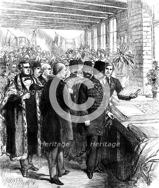 The Shah at Manchester: inspecting a piece of calico printed with Persian words of welcome, 1873. Creator: Unknown.