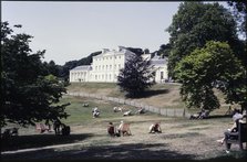 A view from the south-east looking towards Kenwood House, with people relaxing on the lawn..., 1984. Creator: Dorothy Chapman.