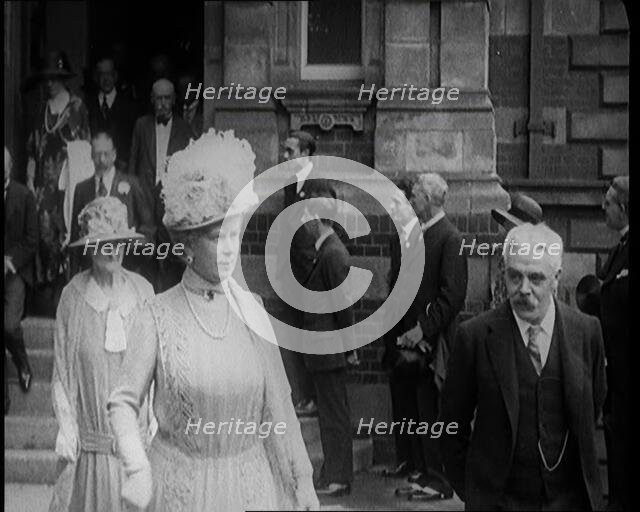 Queen Mary and King George V Accompanied by a Group of Officials Emerging from a Building , 1924. Creator: British Pathe Ltd.
