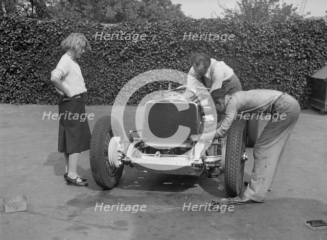 Working on the engine of Raymond Mays' Vauxhall-Villiers, c1930s. Artist: Bill Brunell.
