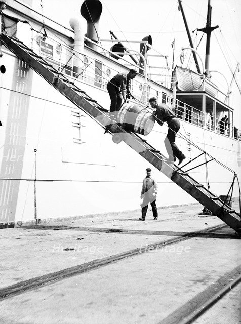 Unloading a barrel from a ship down a gangway, London, c1905. Artist: Unknown