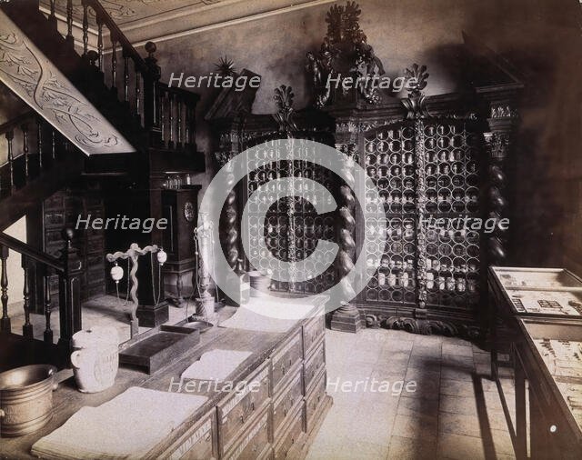 An eighteenth-century apothecary's shop with intricately carved wooden showcases; recreated.... Creator: Unknown.