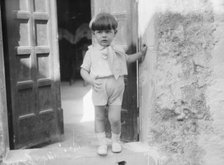 Cenerini, Mr., child of, standing in a doorway, 1929 Creator: Arnold Genthe.