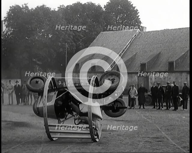 A Crashable Car With a Circular Frame Allowing It To Roll Over Being Tested in Front of..., 1926. Creator: British Pathe Ltd.