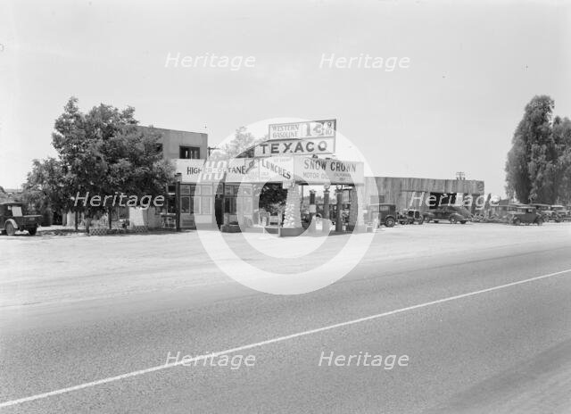 Small independent gas stations litter the highway, near Kingsburg, California, 1939. Creator: Dorothea Lange.