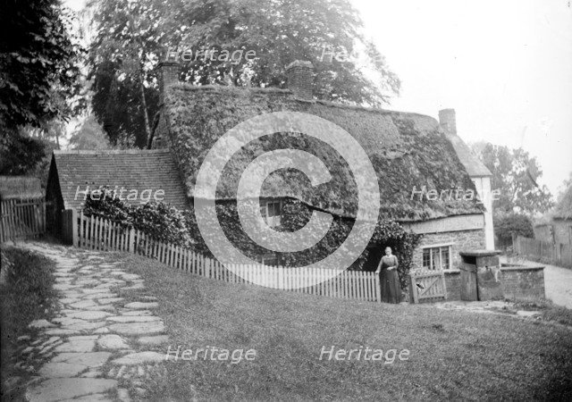 Postmistress in front of the post office at Upper Boddington, Northamptonshire, c1873-c1923. Artist: Alfred Newton & Sons