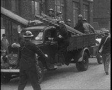 British Air Raid Wardens Arriving at a Phoney Air Raid Scene, 1940. Creator: British Pathe Ltd.