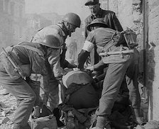 British Medics Helping a Fellow Soldier, 1943-1944. Creator: British Pathe Ltd.