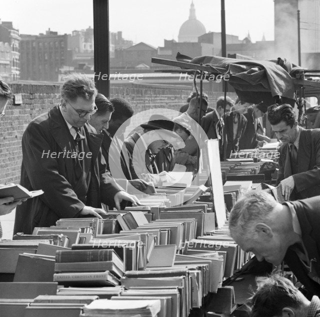A row of men browse an open air second hand bookseller's stall, Finsbury, London, c1946-c1959. Artist: John Gay